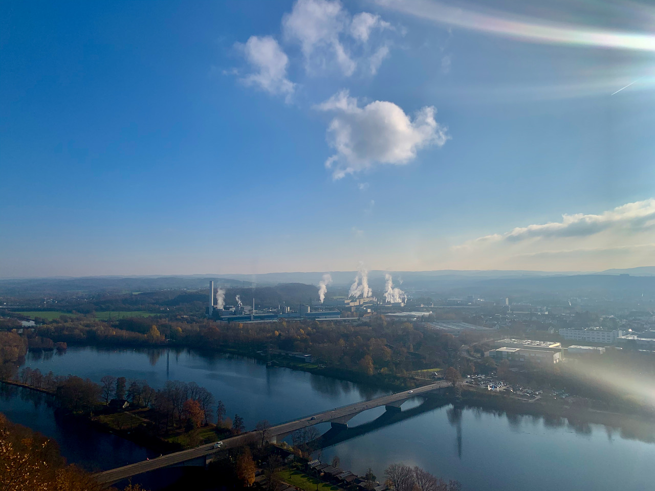 Fernsicht von Dortmund-Hohensyburg über Hagen. Im Vordergrund rauchen Schornsteine.